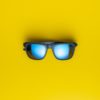 Fashion sunglasses on yellow background.